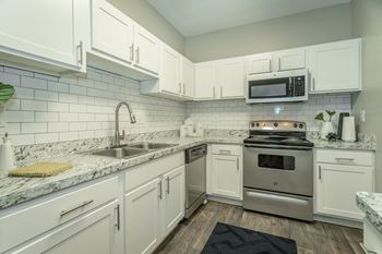 a kitchen with white cabinets and a stainless steel stove  at Avenues of Kennesaw East & West, Georgia, 30144